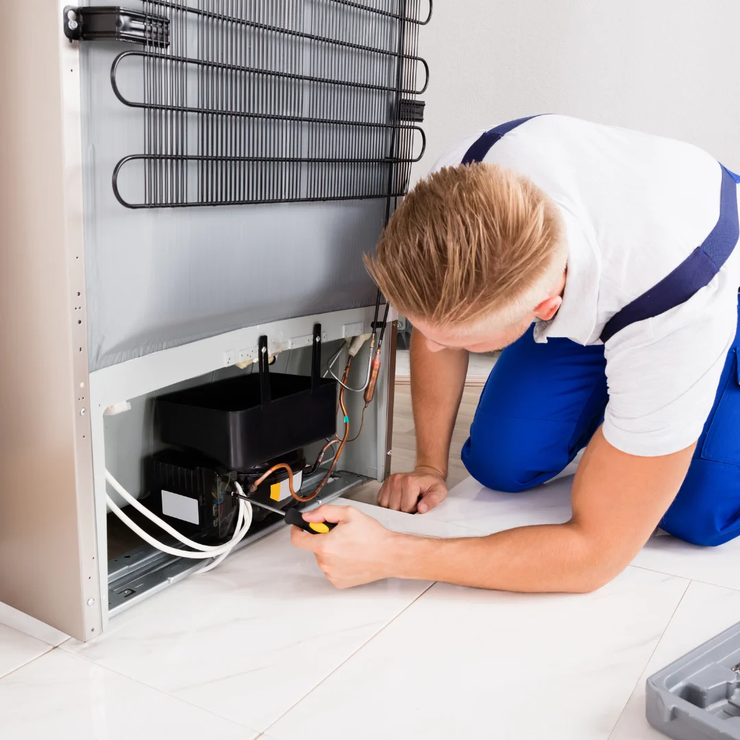 Técnico consertando geladeira